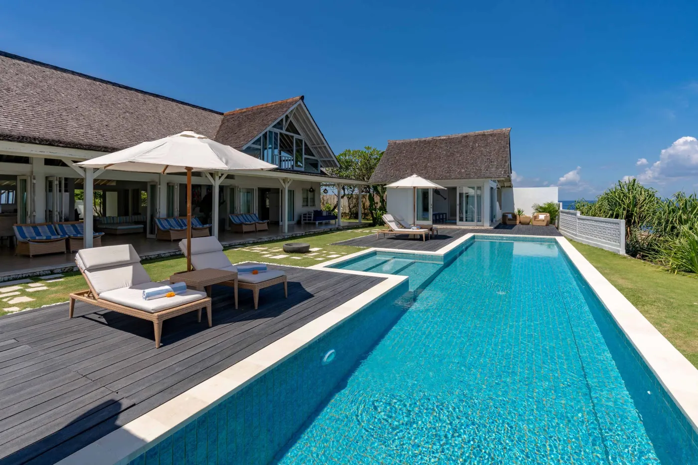 Luxurious Balinese villa with infinity-edge pool, teak loungers, and tropical ocean views. - Bali Villas